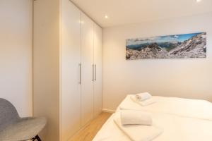 a bedroom with white cabinets and a bed at Bergzauber in Fischen
