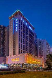 Un palazzo alto con un cartello sul lato. di Hotel Presidente Macau a Macao