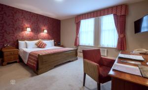 a hotel room with a bed and a desk at Metropole Hotel and Spa in Llandrindod Wells