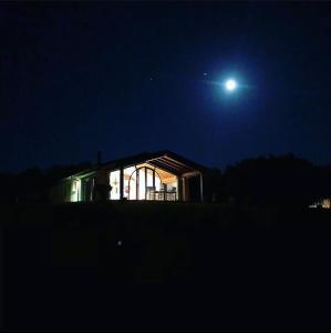 Una casa de noche con la luna en el cielo en La RIMESSA EXPERIENCE, en Montaione