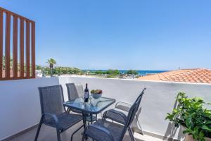 a table and chairs on a balcony with a view of the ocean at Bivalvia Studios in Faliraki