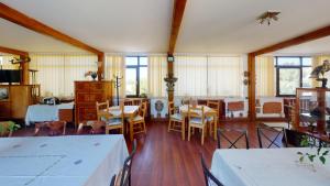 a dining room with tables and chairs and windows at Villa Giulia in Islaz