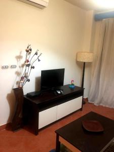 A television and/or entertainment centre at Amazing view apartment in Golf Porto Marina with marina access
