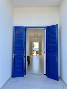 une porte bleue ouverte menant à un couloir dans l'établissement Villa Caponegro, à Avola