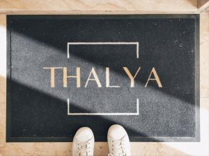 Un paio di scarpe su una lavagna con la parola Thailandese di Thalya Luxury Rooms a Siracusa