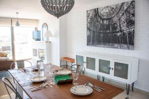 a dining room with a table with plates and glasses at Apartamento con Vistas S'agaró in Sant Feliu de Guixols