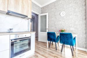 une cuisine avec une table et deux chaises bleues dans l'établissement Raisson Ahotel B172, à Astana