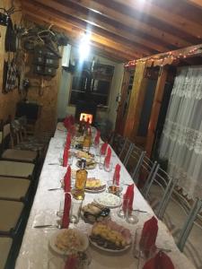 einen langen Tisch mit Teller mit Lebensmitteln drauf in der Unterkunft Guest House Pri Germanetsa in Pavel Banya