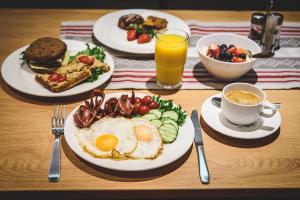 Hotel Karupesa في أوتيبا: طاولة مع أطباق من طعام الإفطار وكوب من عصير البرتقال