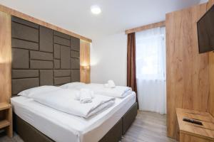 ein Schlafzimmer mit einem großen Bett mit weißer Bettwäsche in der Unterkunft Apartments Maiskogelblick in Piesendorf