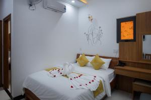 1 dormitorio con 1 cama con sábanas y almohadas blancas en Kim Hoàn Hotel Phan Rang en Phan Rang