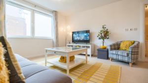 a living room with a couch and a tv at Hansen Court - Stylish Bay Apartment with Designated Parking in Cardiff