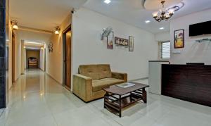 a living room with a chair and a coffee table at Treebo Trend Apple Tree Apartment & Suites in Bangalore