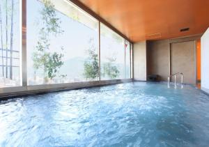 a large swimming pool in a building with a large window at Urban Hotel Kyoto Gojo Premium in Kyoto