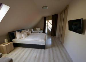 1 dormitorio con 1 cama con sábanas blancas y ventana en Rubin Apartman Zalakaros, en Zalakaros