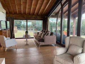 sala de estar con sofás, sillas y TV en La RIMESSA EXPERIENCE, en Montaione