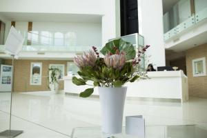 a white vase with flowers in a lobby at Smeraldo Suites & Spa in San Benedetto del Tronto
