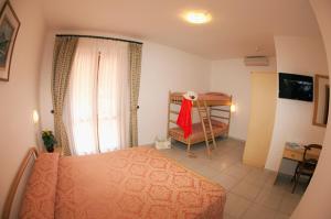 
a bedroom with a bed and a dresser at Hotel Lo Scirocco in Campo nell'Elba
