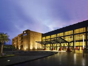 a large building with a lit up facade at Novotel Hyderabad Convention Centre in Hyderabad