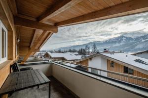 a balcony with a view of snow covered mountains at Maiskogelblick Apartments by we rent in Piesendorf