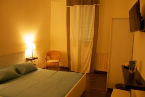 ein Schlafzimmer mit einem Bett, einem Stuhl und einem Fenster in der Unterkunft B&B Casa Bologna in Bologna