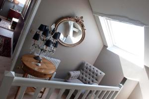 a staircase with a mirror and a table and a chair at Domaine de la Soucherie - Chambres d'hôtes in Beaulieu-sur-Layon