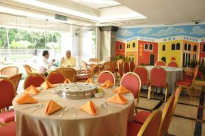a restaurant with tables and chairs and people sitting at tables at Tang Dynasty Park Hotel in Kota Kinabalu