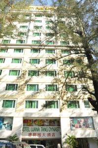 a tall white building with a tree in front of it at Tang Dynasty Park Hotel in Kota Kinabalu