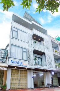 クイニョンにあるNHÀ TUI Share Quy Nhơn Serviced Apartmentの看板が貼られた白い建物