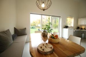 uma sala de estar com uma mesa de madeira e uma cozinha em Nordic Park em Græsted