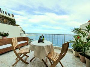 een tafel en stoelen op een balkon met uitzicht op de oceaan bij Ocean Wave by TOR in Puerto de la Cruz