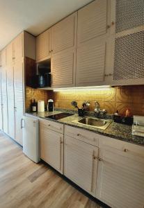 a kitchen with wooden cabinets and a sink and a refrigerator at Ocean Wave by TOR in Puerto de la Cruz