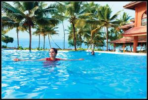 una mujer nadando en una piscina en un complejo en Lakesong Resort en Kumarakom