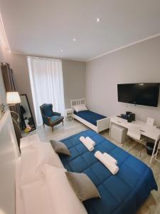 1 cama azul grande en una sala de estar con TV. en Bed And Best, en Roma