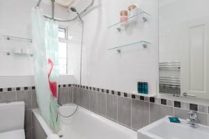 a bathroom with a tub and a toilet and a sink at GuestReady - Homely and Serene 1Bed Apartment in Islington in London