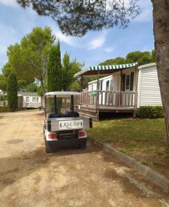 a golf cart parked in front of a house at Mobile Homes by KelAir at Castell Montgri in Torroella de Montgrí