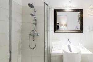 a bathroom with a shower and a sink and a mirror at Villa Aurora in Bojanowo