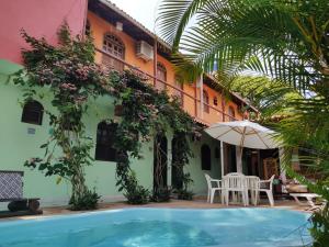 a resort with a swimming pool and a building at Pousada Rota Tropicana in Arraial d'Ajuda