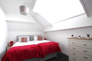 ein Schlafzimmer mit einem Bett mit einer roten Decke in der Unterkunft Coast Accommodation Station Road Apartments in Blackpool