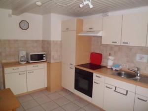 a kitchen with white cabinets and a sink at Ferienwohnung Angelika und Guenter in Handewitt