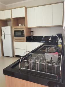 a dish drying rack on a counter in a kitchen at Casa beira mar Torres in Torres +18 photos