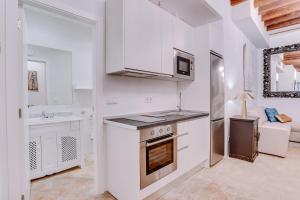a kitchen with white cabinets and a stove top oven at Vintage Palma Palace Apartments TI by PriorityVillas in Palma de Mallorca