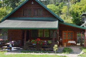 a log cabin with flowers in front of it at Holiday Homes Biser Lopatnice in Lopatnica