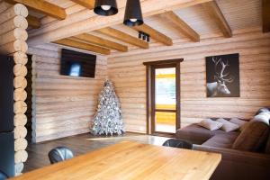 Sala de estar con mesa y árbol de Navidad en Шале Вілія, en Vorokhta
