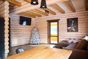 a living room with a table and a christmas tree at Шале Вілія in Vorokhta