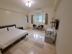 1 dormitorio con 1 cama, mesa y sillas en ShiGuo Homestay, en Xiulin