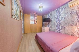 a bedroom with a bed and a tv on a wall at Двухкомнатные апартаменты рядом с вокзалом in Sochi