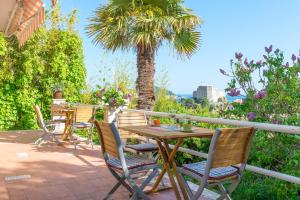 een tafel en stoelen op een patio met een palmboom bij Ankora sea and Old Town view - HOT TUB in Dubrovnik