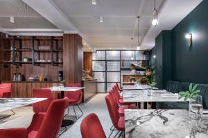 a dining room with tables and red chairs at Hotel Tim's in Skopje