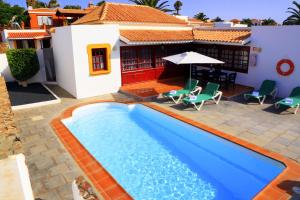 una piscina frente a una casa en Vip Villas - Caleta Dorada, en Caleta de Fuste